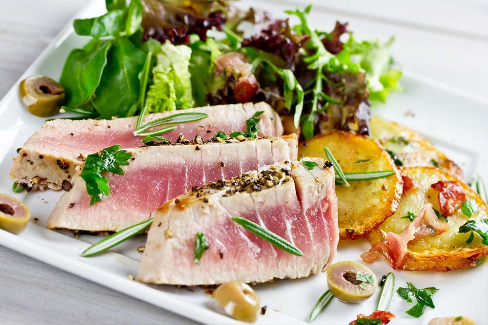 Thunfisch-Steaks mit Kartoffeln, Oliven und Salat