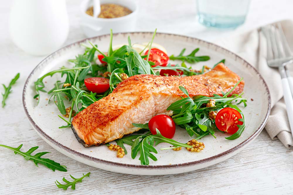 Wildlachs auf Rucola und mit Tomaten serviert